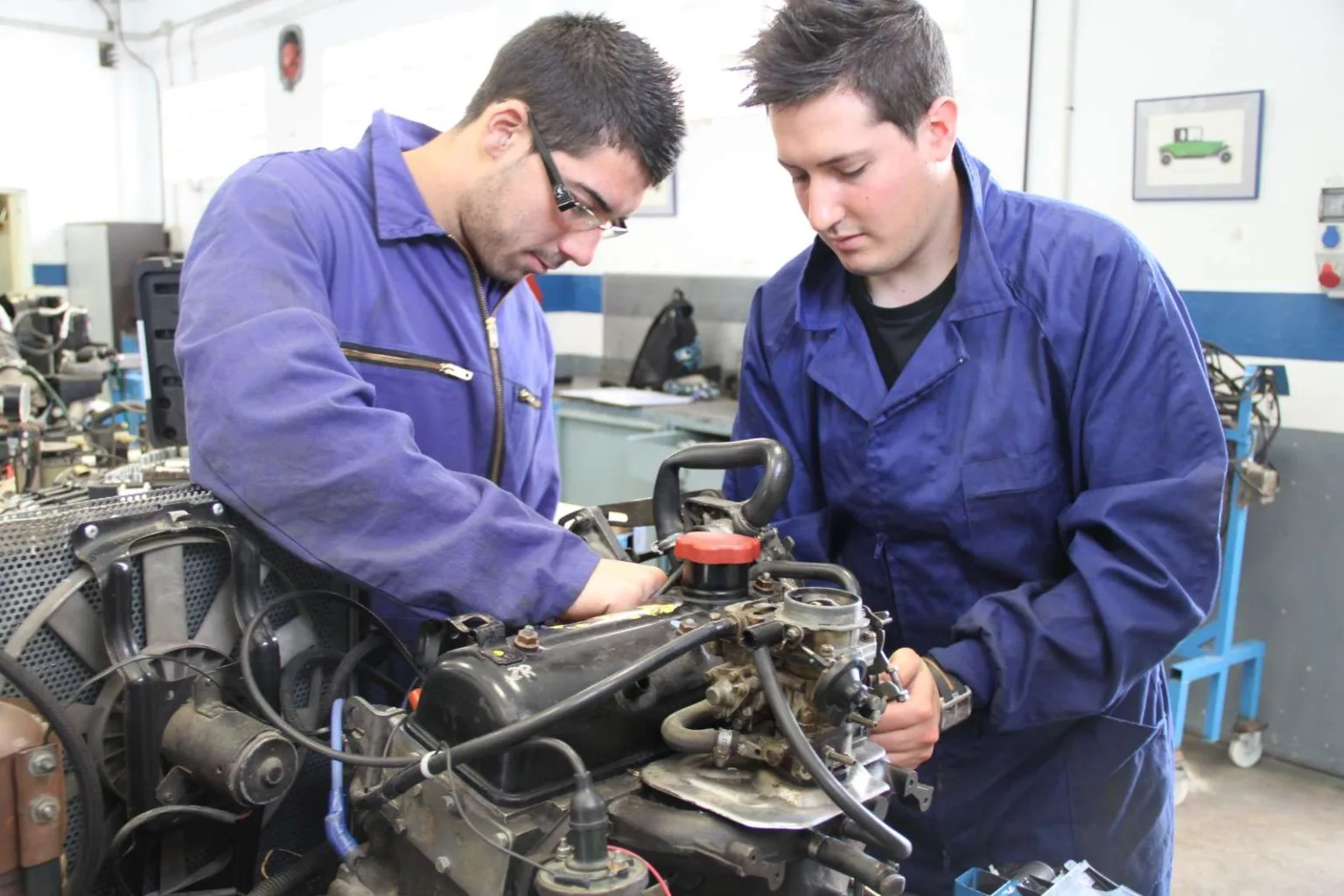 Alumnos de Formación Profesional trabajando sobre un motor en el taller de automoción