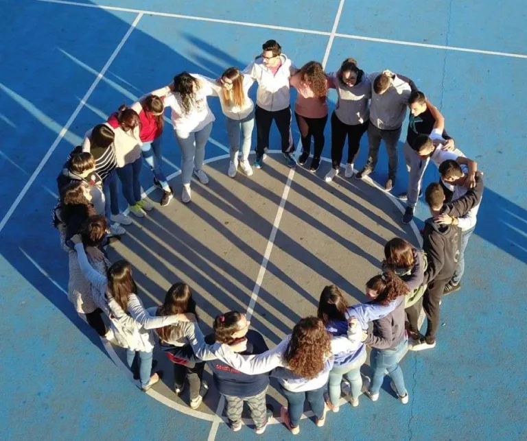 Alumnos en corro en la pista deportiva durante una actividad