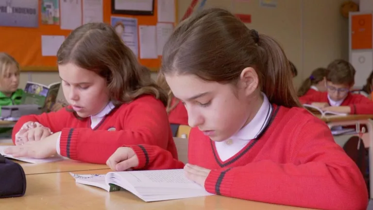 Alumnas de Educación Primaria leyendo juntas en clase