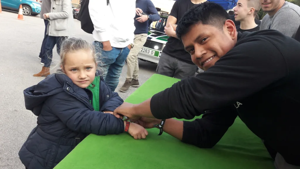 Un alumno de Automoción echa un pulso con una niña junto al coche del Panda Raid