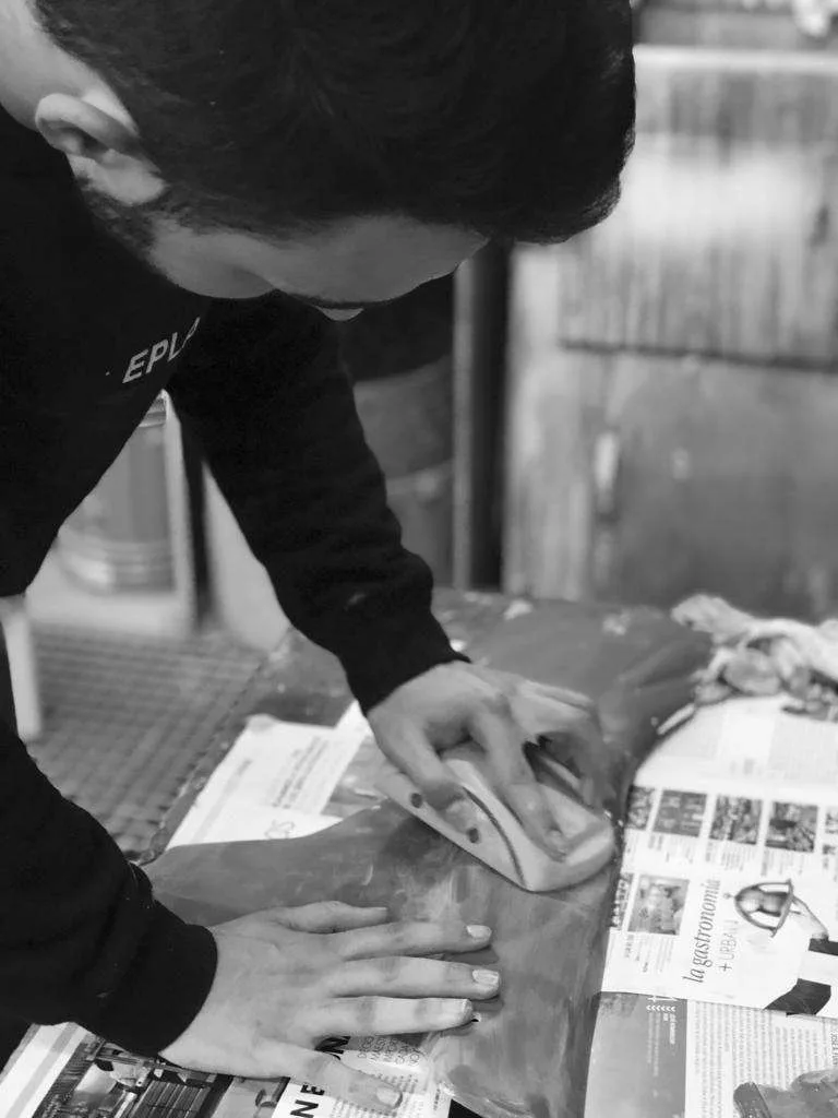 Alumno de Automoción lijando una pieza del vehículo