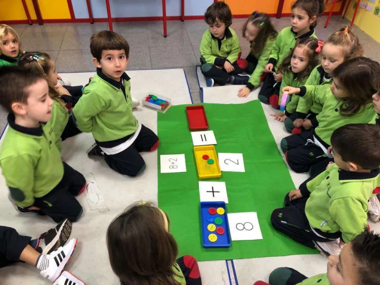 Alumnos de Educación Infantil trabajando con un juego de números en el suelo del aula